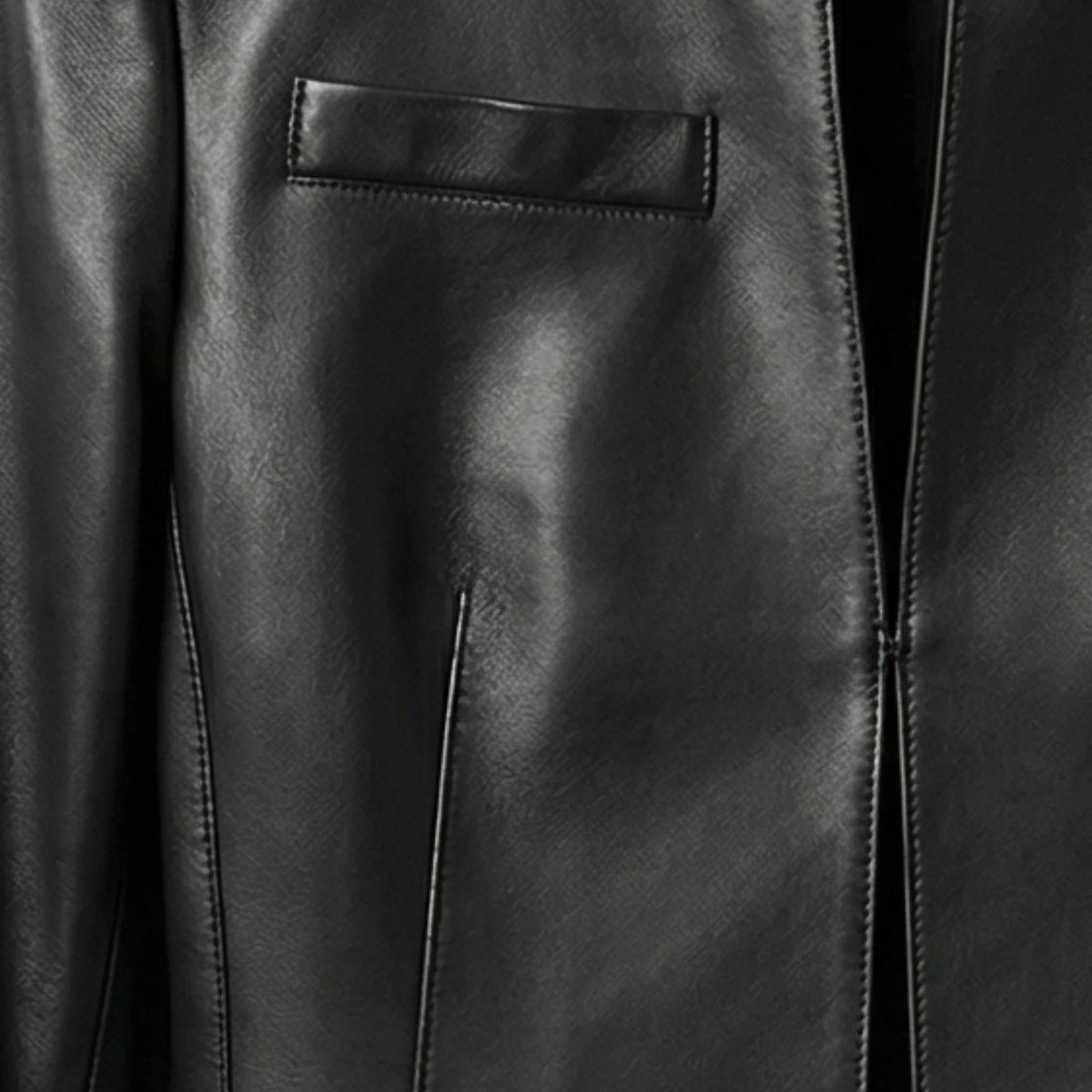 Close-up of chest welt pocket and front opening on women's black leather crop jacket