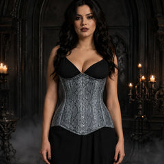 Woman wearing grey snake print faux leather underbust corset with front busk over a simple black gothic outfit.