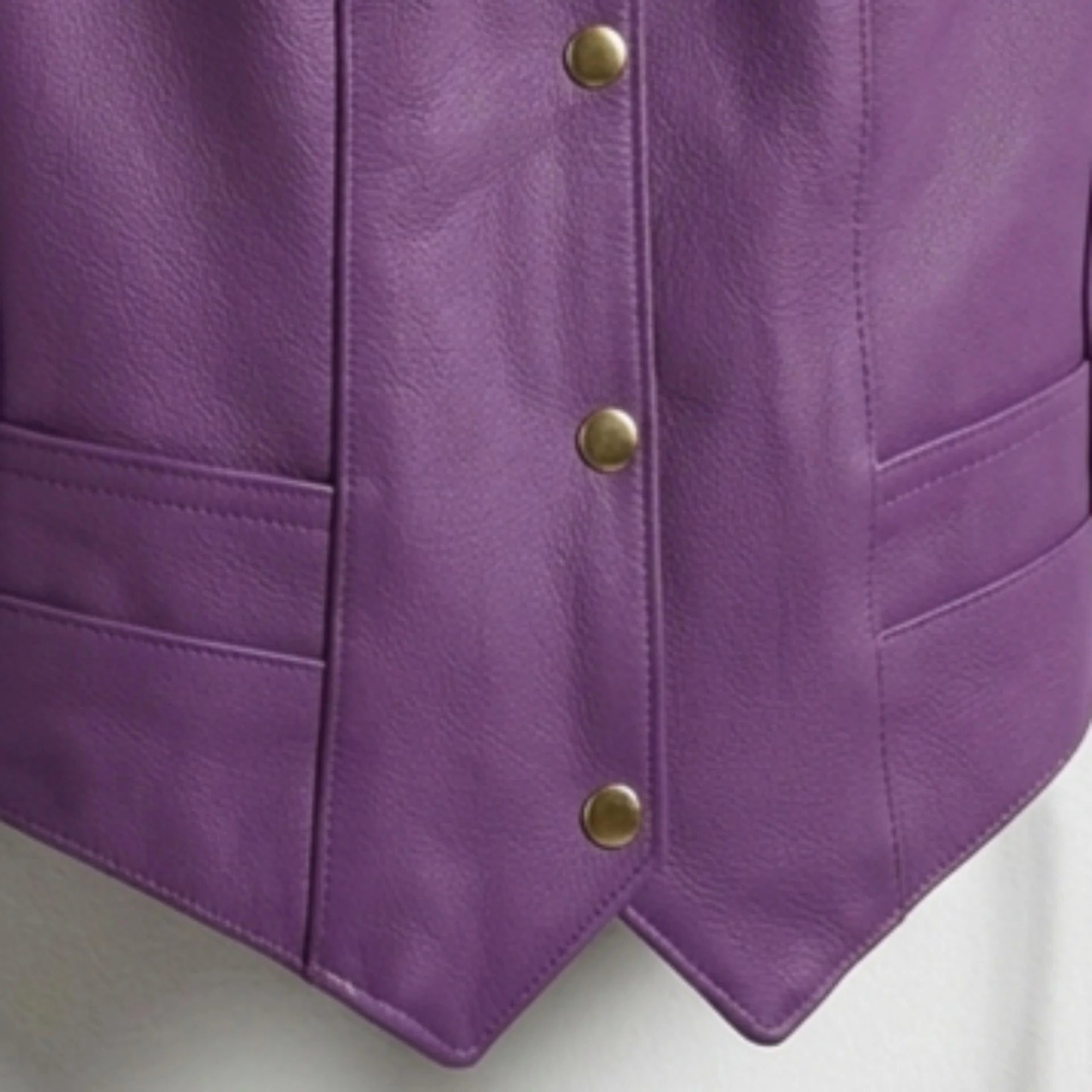 Close up of snap button closure and pointed hem of purple leather vest