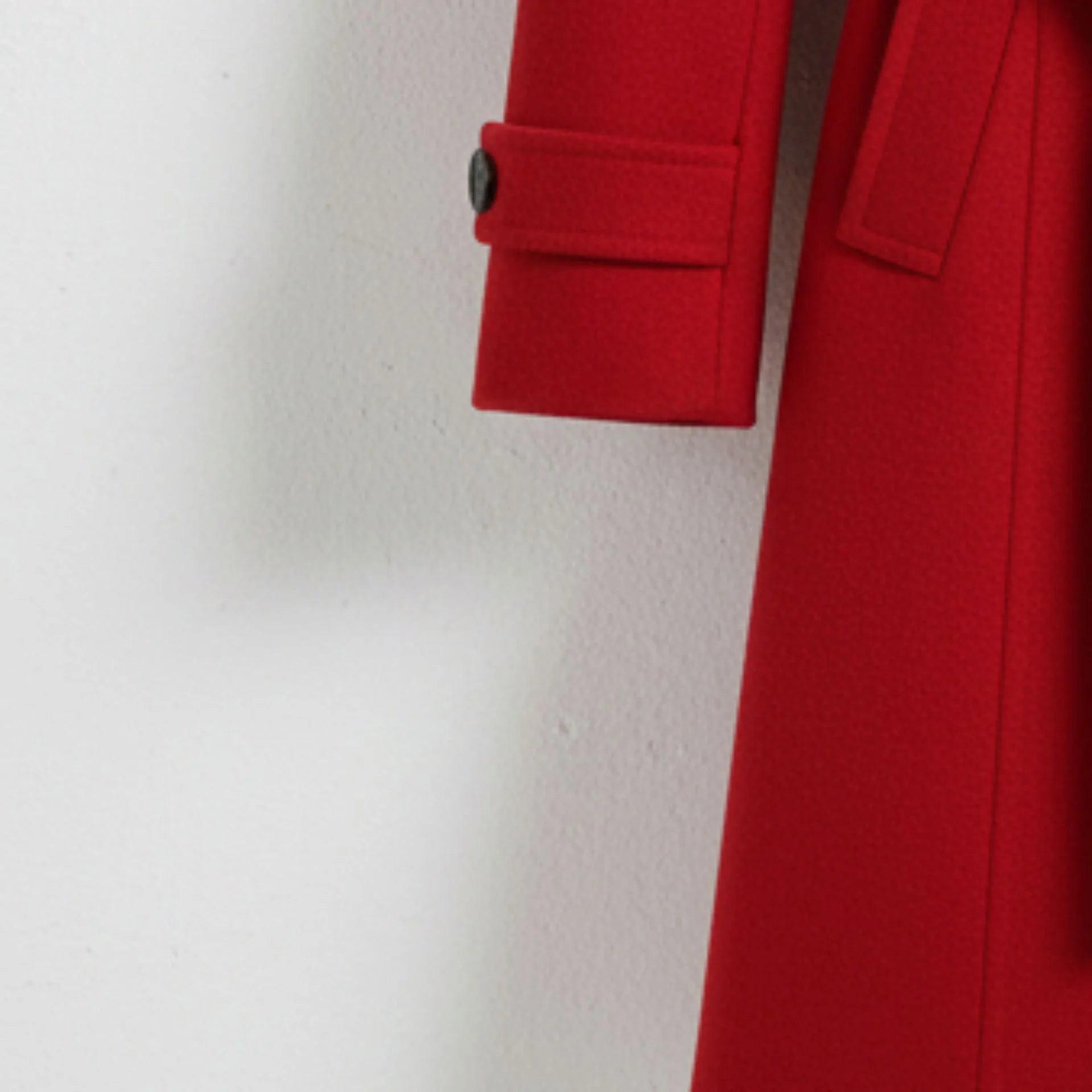 Close up of button tab cuff on women’s red wool coat