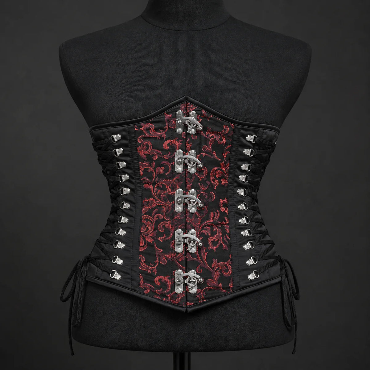 Front mannequin view of red brocade underbust corset with five metal clasps and black adjustable side lacing