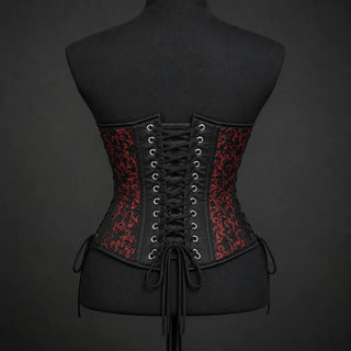 Back mannequin view of red brocade corset showing black central cross lacing, eyelets and patterned side panels