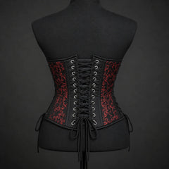 Back mannequin view of red brocade corset showing black central cross lacing, eyelets and patterned side panels