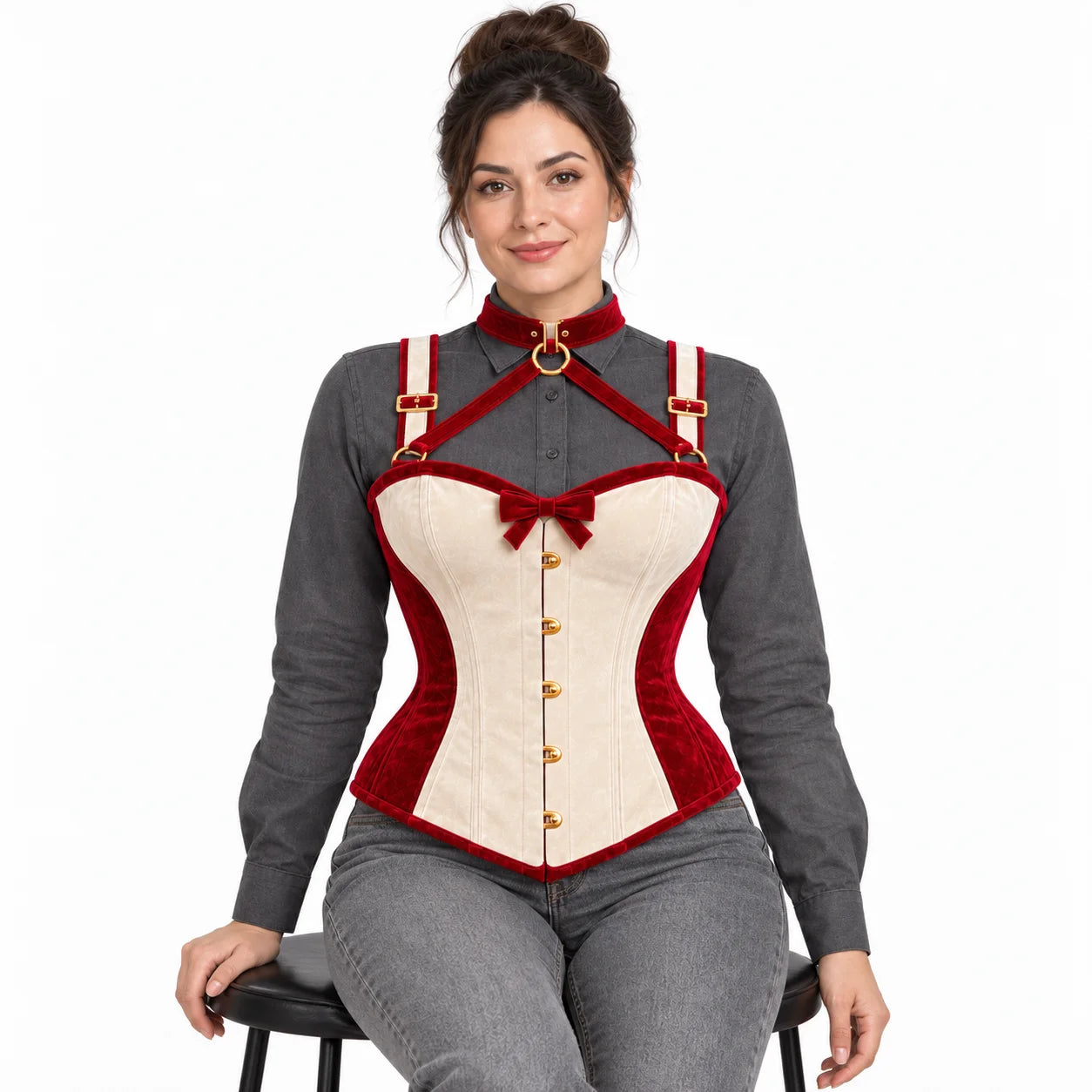Seated model wearing a women's ivory and cranberry velvet corset with neck harness and gold-tone hardware