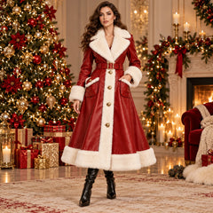 Model wearing a long red leather Christmas coat with white faux fur trim and a matching belt beside a decorated Christmas tree.