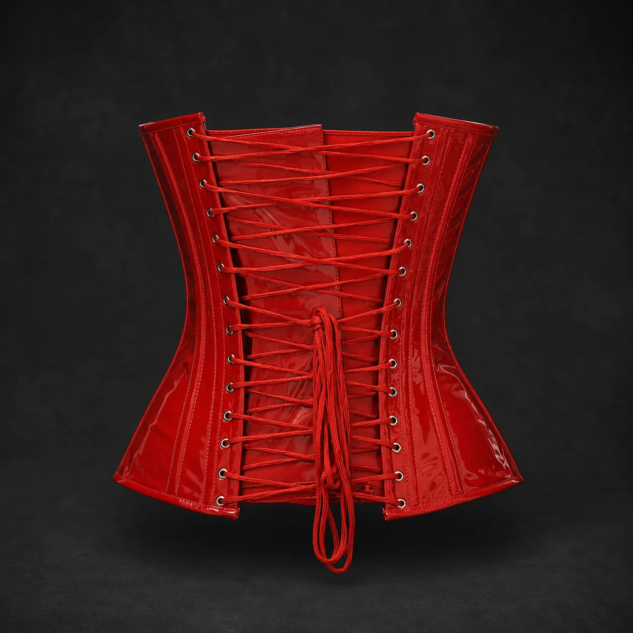 Back product view of red PVC corset with adjustable lace-up closure, multiple metal eyelets and matching red lacing