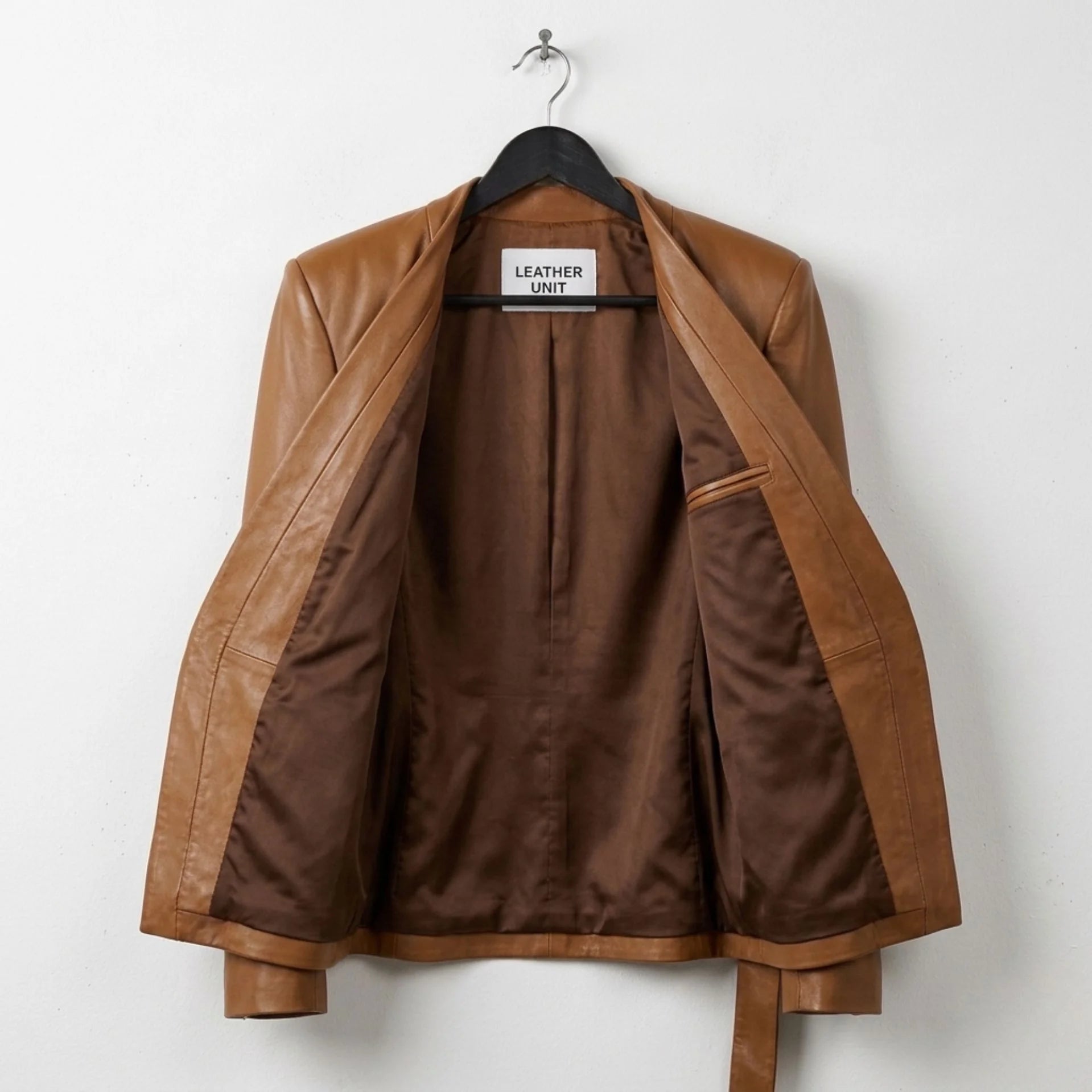 Interior lining of womens brown wrap leather jacket showing inner pocket